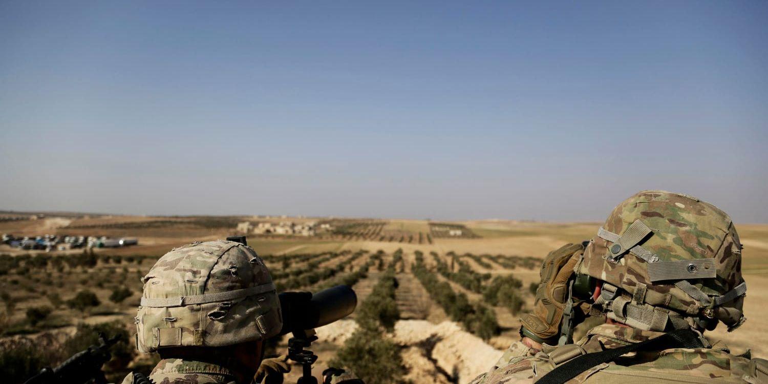Amerikanska soldater tittar mot den turkiska gränsen från staden Manbij i norra Syrien.