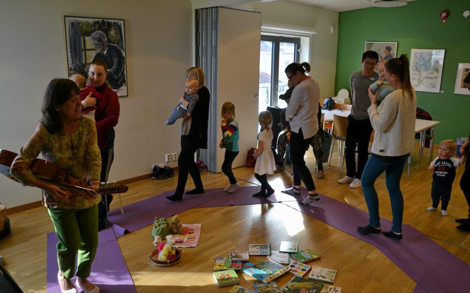 Fredagsmys. Barn och föräldrar dansar runt till Maria Karlsson Runges gitarrspelande på Kulturhuset Kajutan.