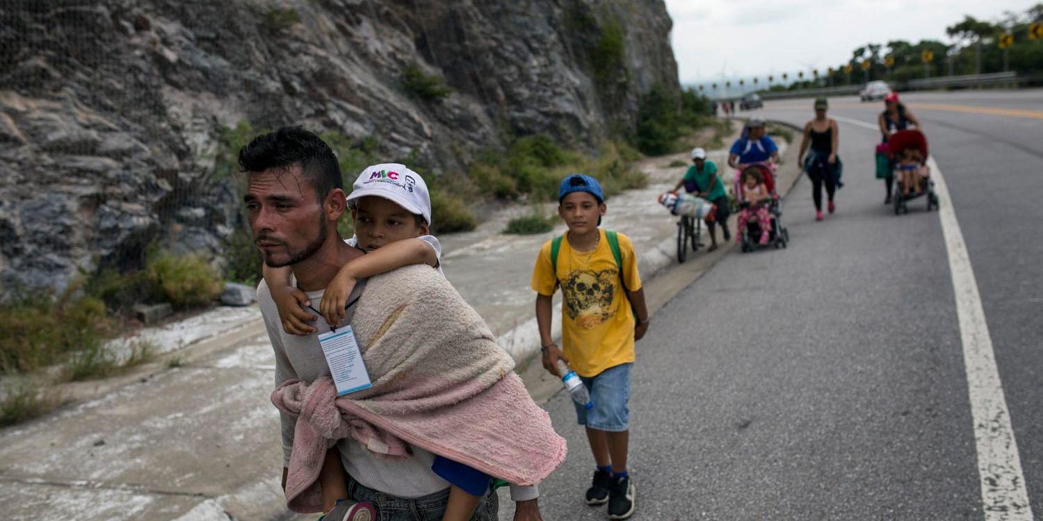Honduranske migranten Jose Macy bär sin fyraårige syskonson Yair Perez på väg mot USA.