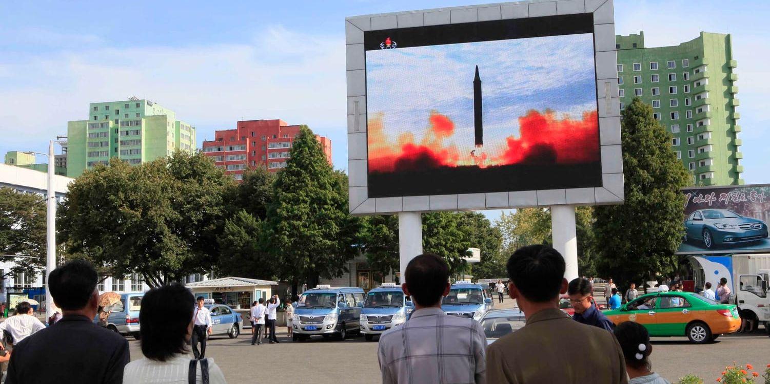 Invånare i Pyongyang i Nordkorea tittar på en skärm som visar uppskjutningen av en ballistisk robot av typen Hwasong-12. Arkivbild.