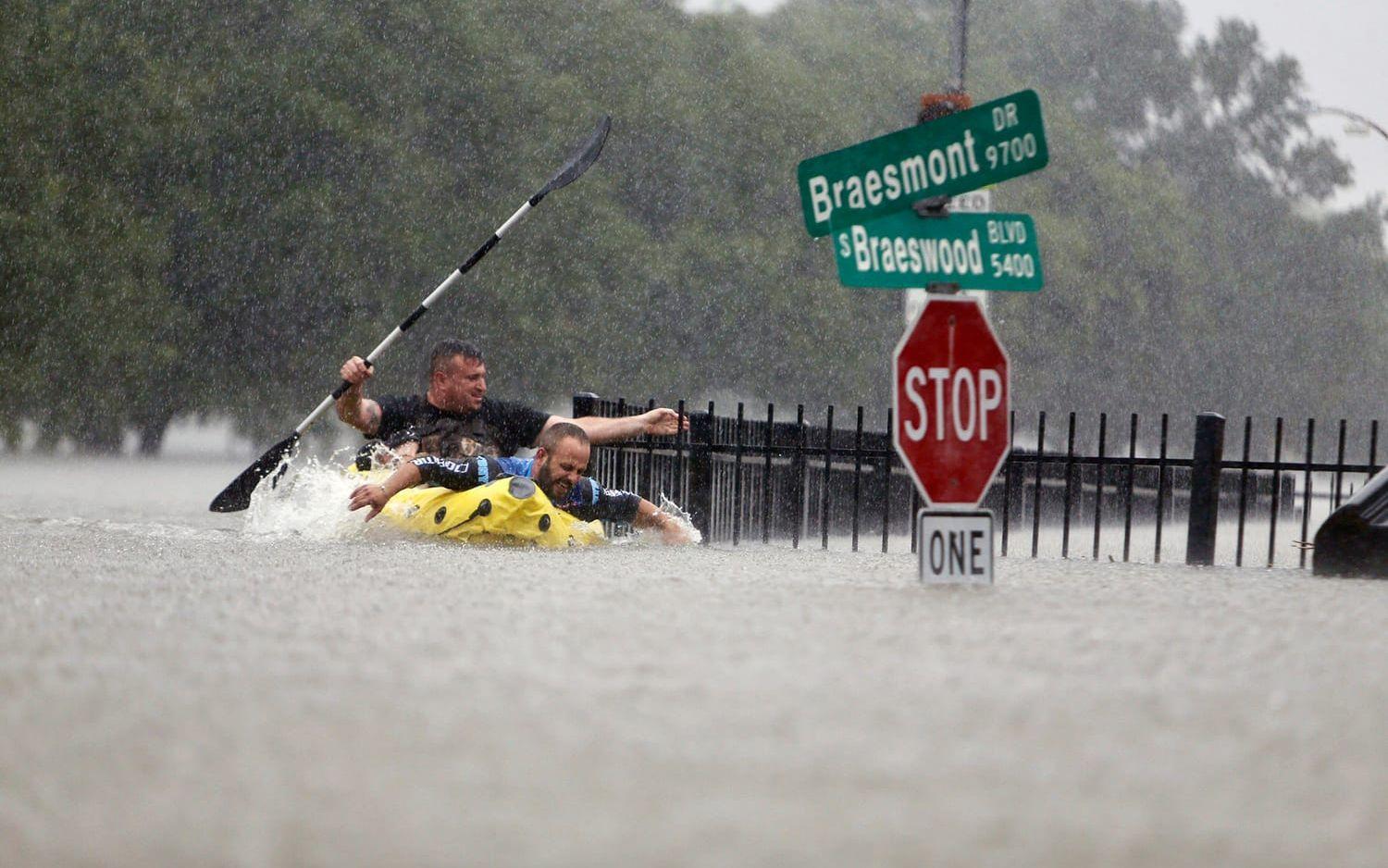 Houston-bor kämpar mot störtflodens strömmar från översvämmade Brays Bayou. FOTO: Mark Mulligan/Houston Chronicle via AP
