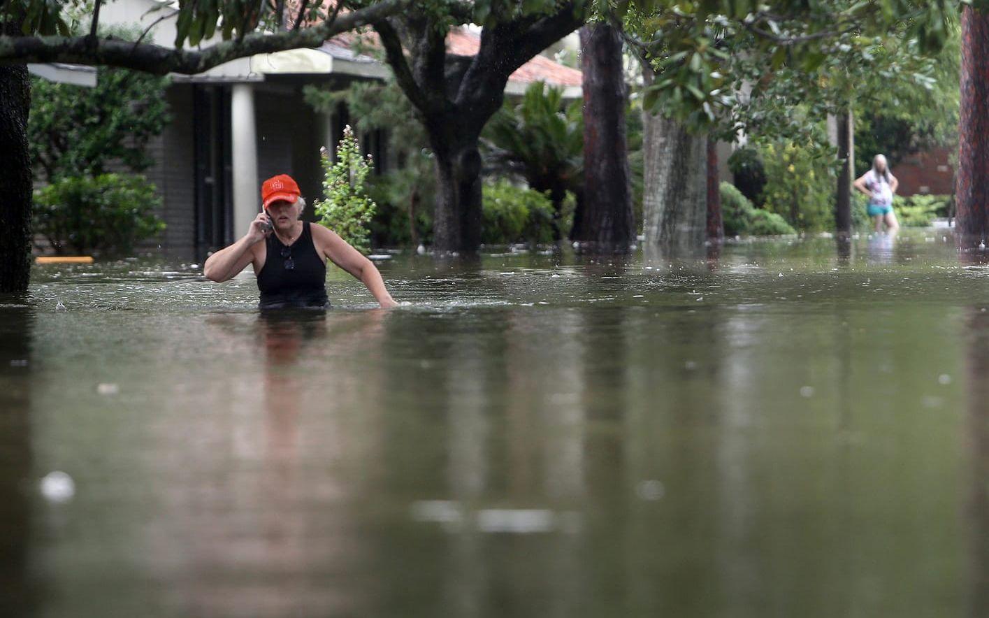 En man vadar längs en översvämmad gata i Meyerland i Houston. FOTO: Mark Mulligan/Houston Chronicle via AP

