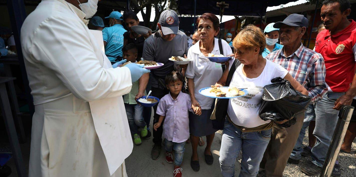 En präst vid en katolsk kyrka delar ut mat till venezuelanska migranter i La Parada, nära Cúcuta, Colombia. Arkivbild.