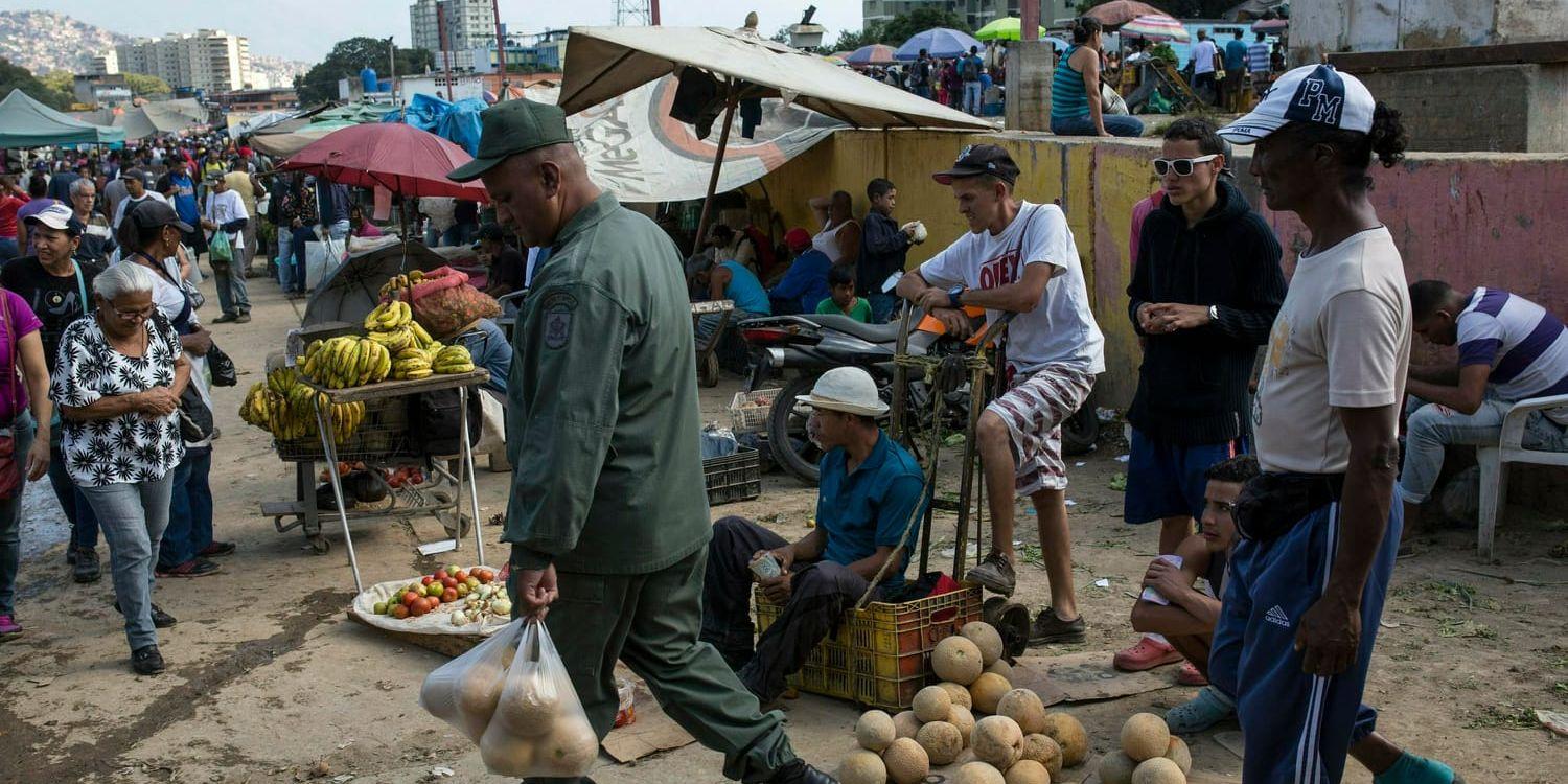 Försäljare och kunder på en matmarknad i Caracas. Krisen i Venezuela förvärras ju längre maktkampen mellan Maduro och Guaidó pågår, enligt experter.