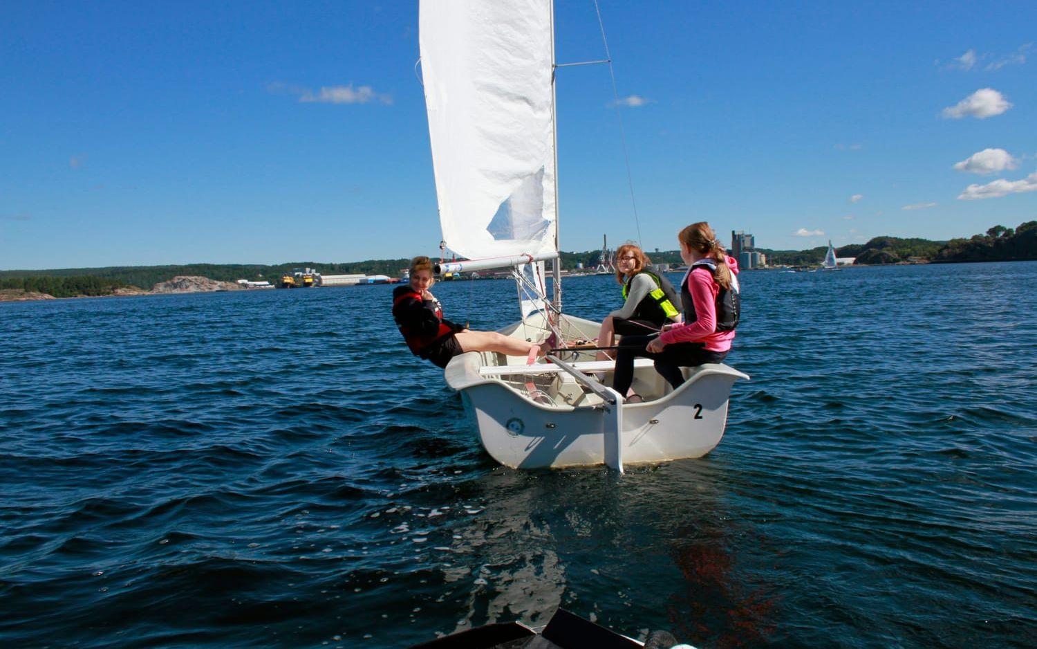 På väg ut mot Byfjorden. Maria Bergman kränger ner båten, Sanna Lidbäck Ljung håller ordning på focken och Alva Hedlund styr. Foto: Ingrid Byström