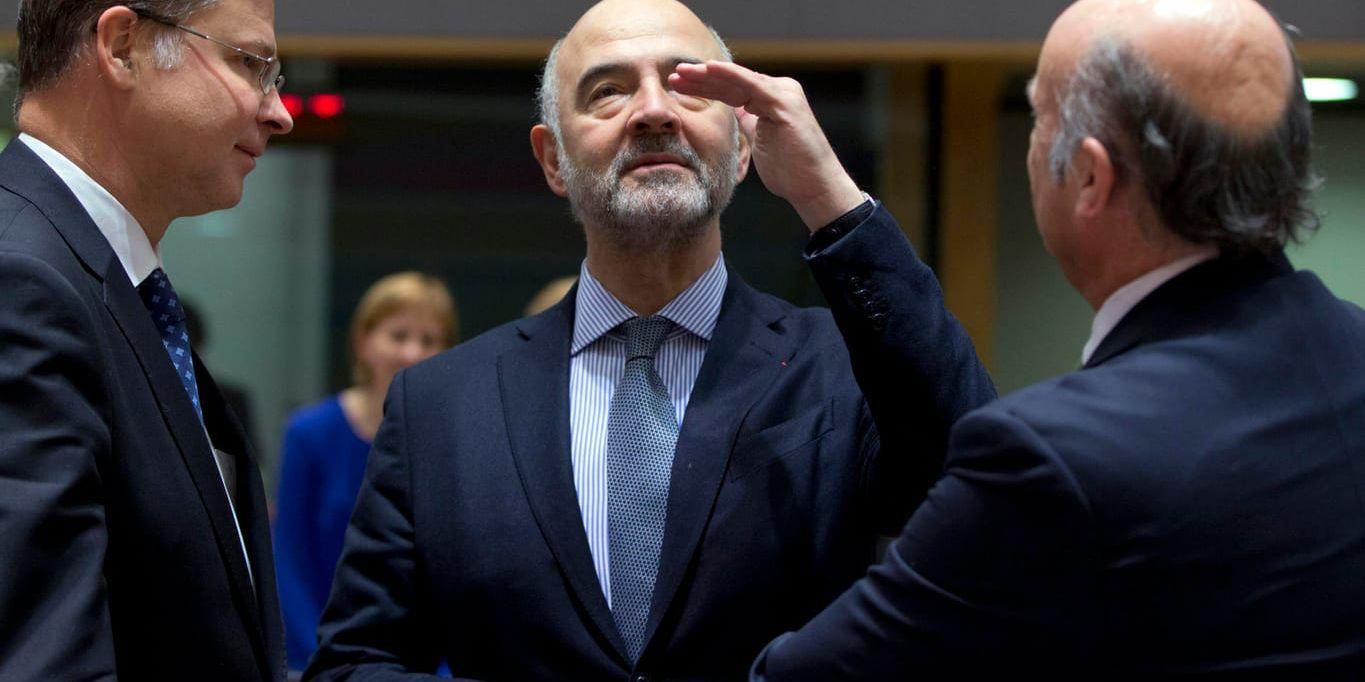 EU:s finanskommissionär Pierre Moscovici (mitten) tvingas sänka de ekonomiska prognoserna. Arkivfoto.