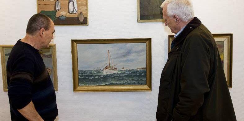 Damir Gutic och Torsten Häller beundrar en tavla från en av Lysekils konstnärer.