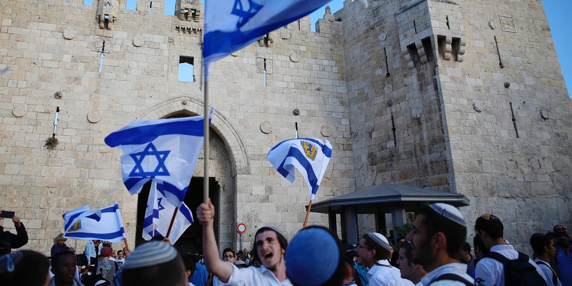 In this Sunday, May 13, 2018, file photo, Israelis wave national flags outside the Old City&apos;s Damascus Gate, in Jerusalem. Israel&apos;s parliament has approved a controversial piece of legislation that defines the country as the nation-state of the Jewish people. Opponents and rights groups have criticized the legislation, warning that it will sideline minorities such as the country&apos;s Arabs. 