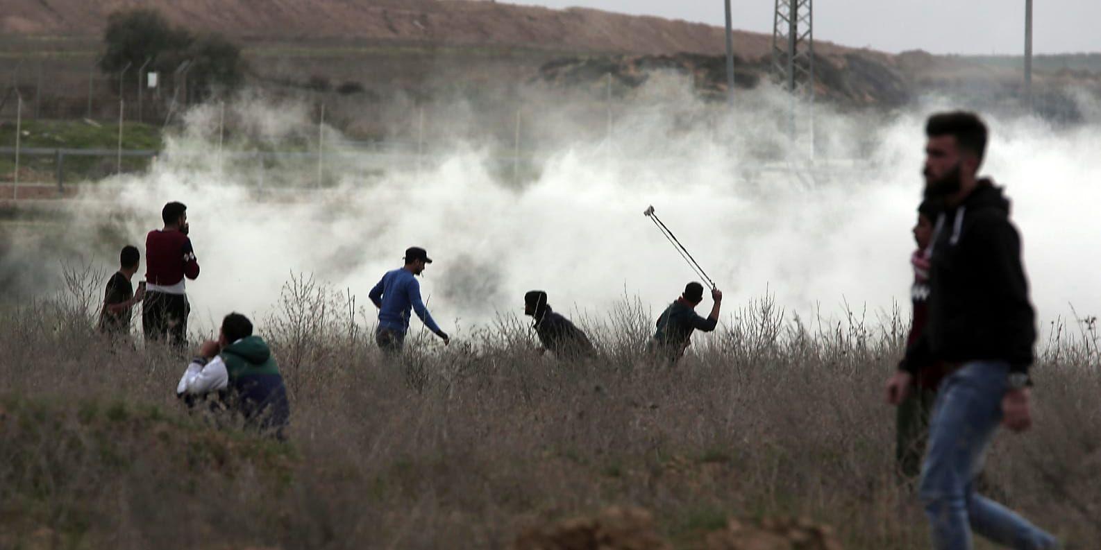 Palestinier med stenslungor vid den israeliska gränsen mot Gaza.