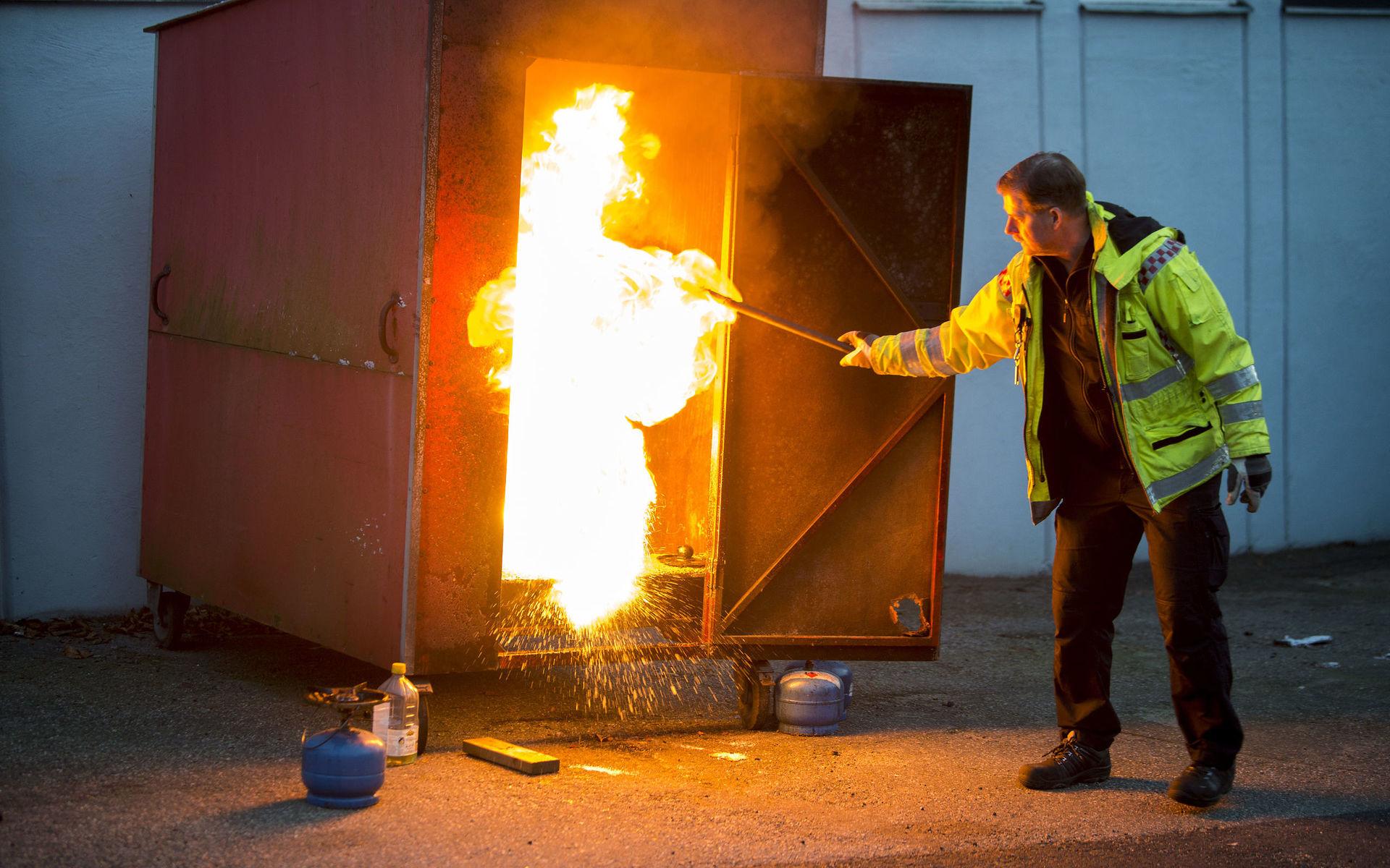 Janne Olsson slår en skopa vatten över en kastrull med brinnande olja. Lågan exploderar en och en halv meter rakt upp.