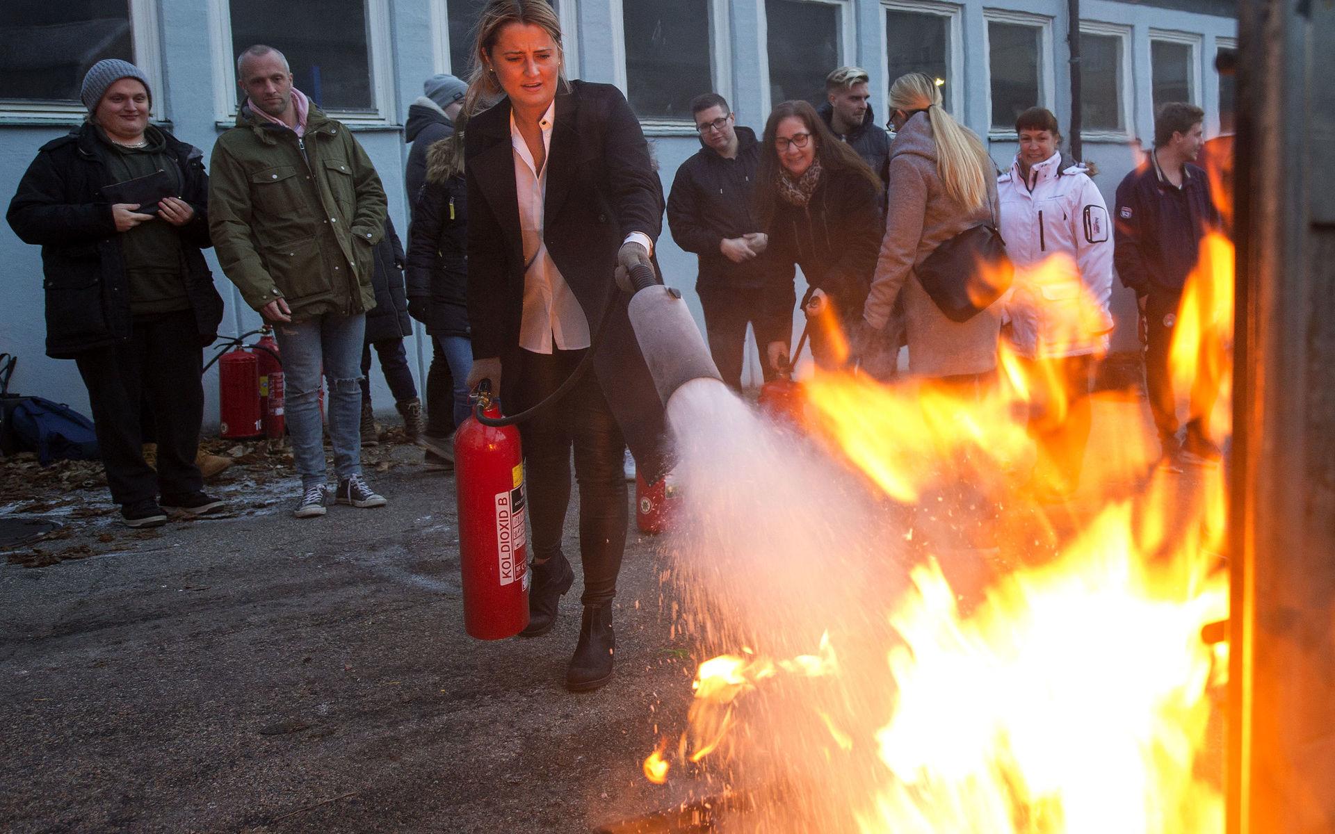 Cèline Alm som är undersköterska på Herrestad hemtjänst prövar att släcka eld med en pulversläckare utanför Uddevalla brandstation. 