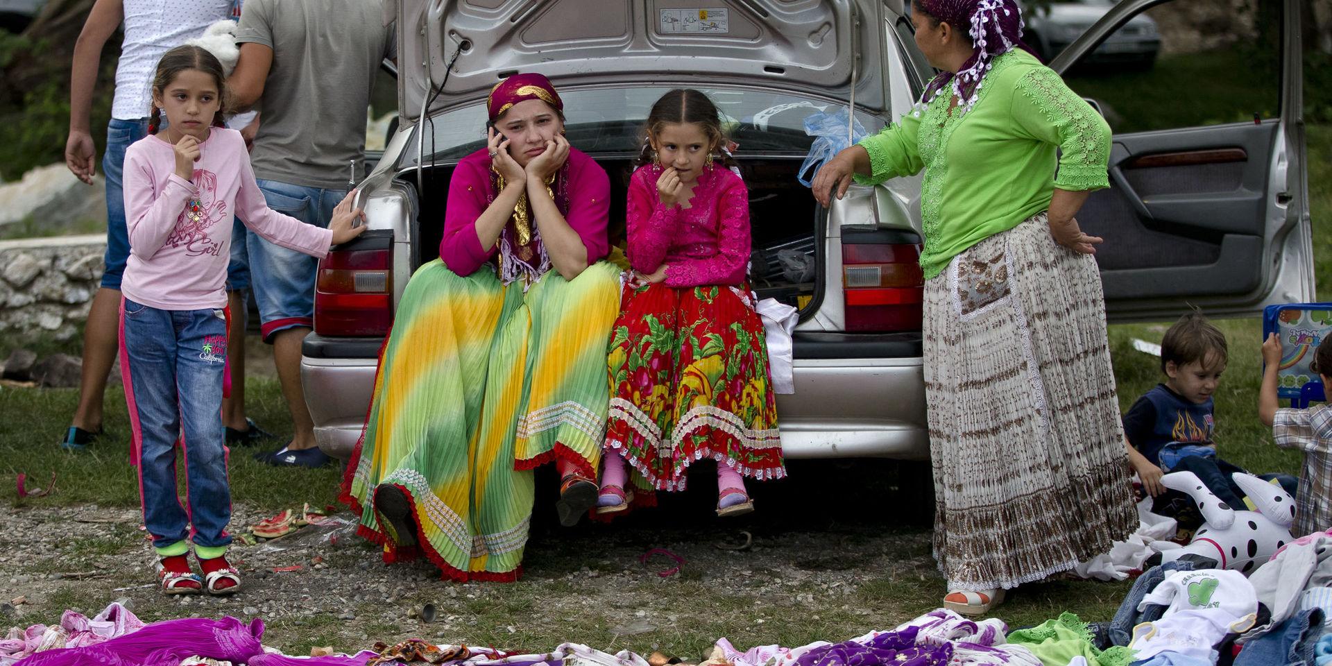 A Roma family waits for customers for traditional skirts as the Roma community celebrates the Birth of the Virgin Mary in Costesti, Romania, Monday, Sept. 8, 2014. Thousands of Gypsies or Roma gather on a hillside after attending a religious service in a nearby monastery and celebrate the religious holiday by sharing food and playing traditional music until the next dawn. (AP Photo/Vadim Ghirda) / TT / kod 436