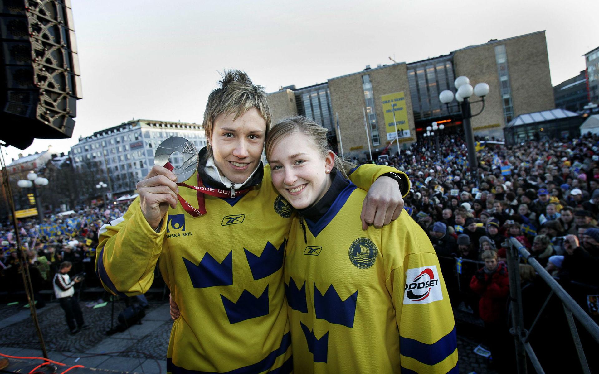 Maria Rooth och målvakten Kim Martin efter OS-silvret i Italien 2006. I Sverige togs landslaget emot av tiotusentals personer på Medborgarplatsen i Stockholm. 
