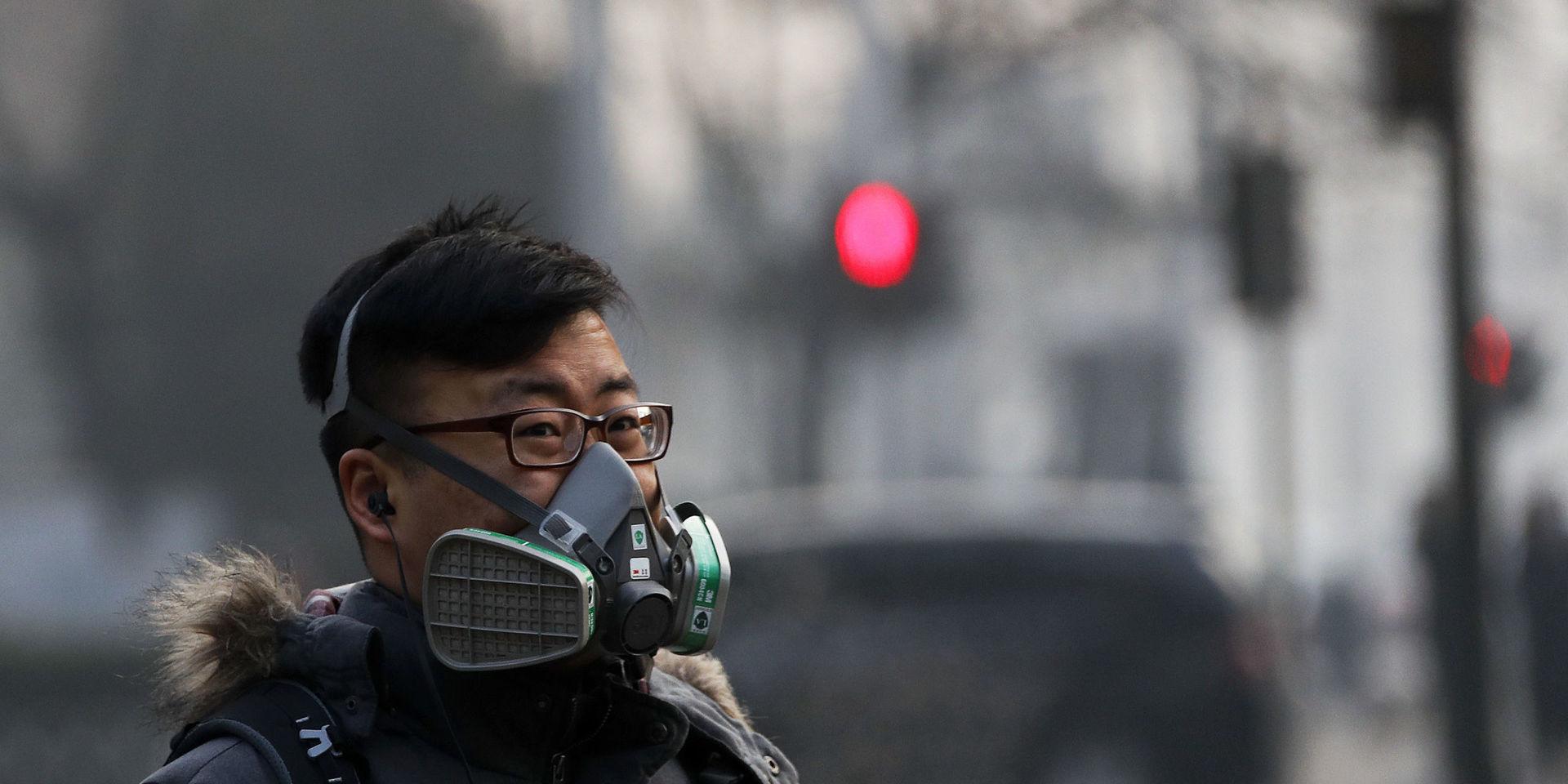A man wearing a mask walks on a street in Beijing as the capital of China is blanked by smog on Friday, Dec. 30, 2016. China has long had some of the worst air in the world, blamed on its reliance on coal and a surplus of older, less efficient cars. It has set pollution reduction goals, but also has plans to increase coal mining capacity and eased caps on production when faced with rising energy prices. (AP Photo/Andy Wong)