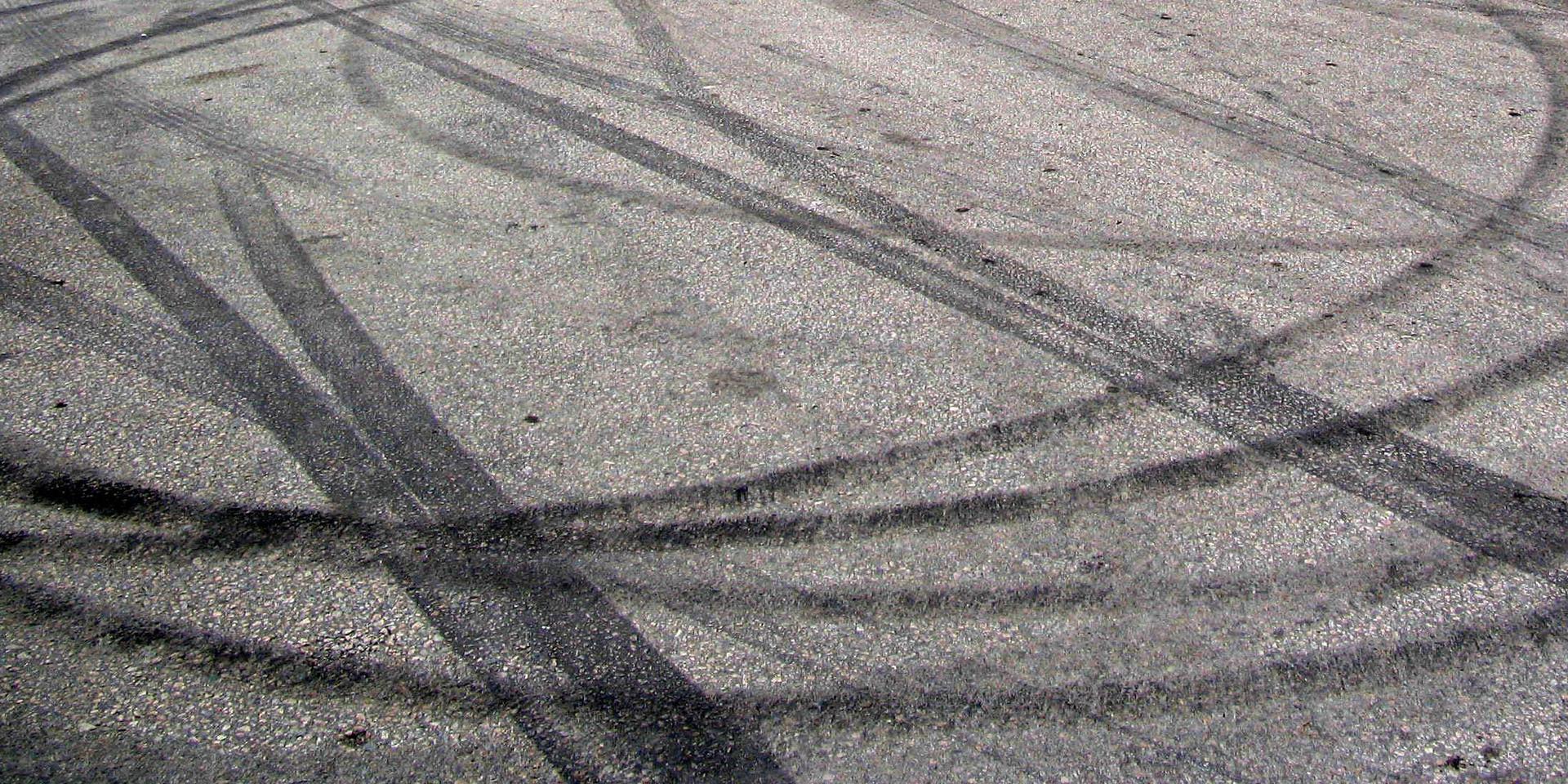 Spår av ofog. Brända däck på asfalt.