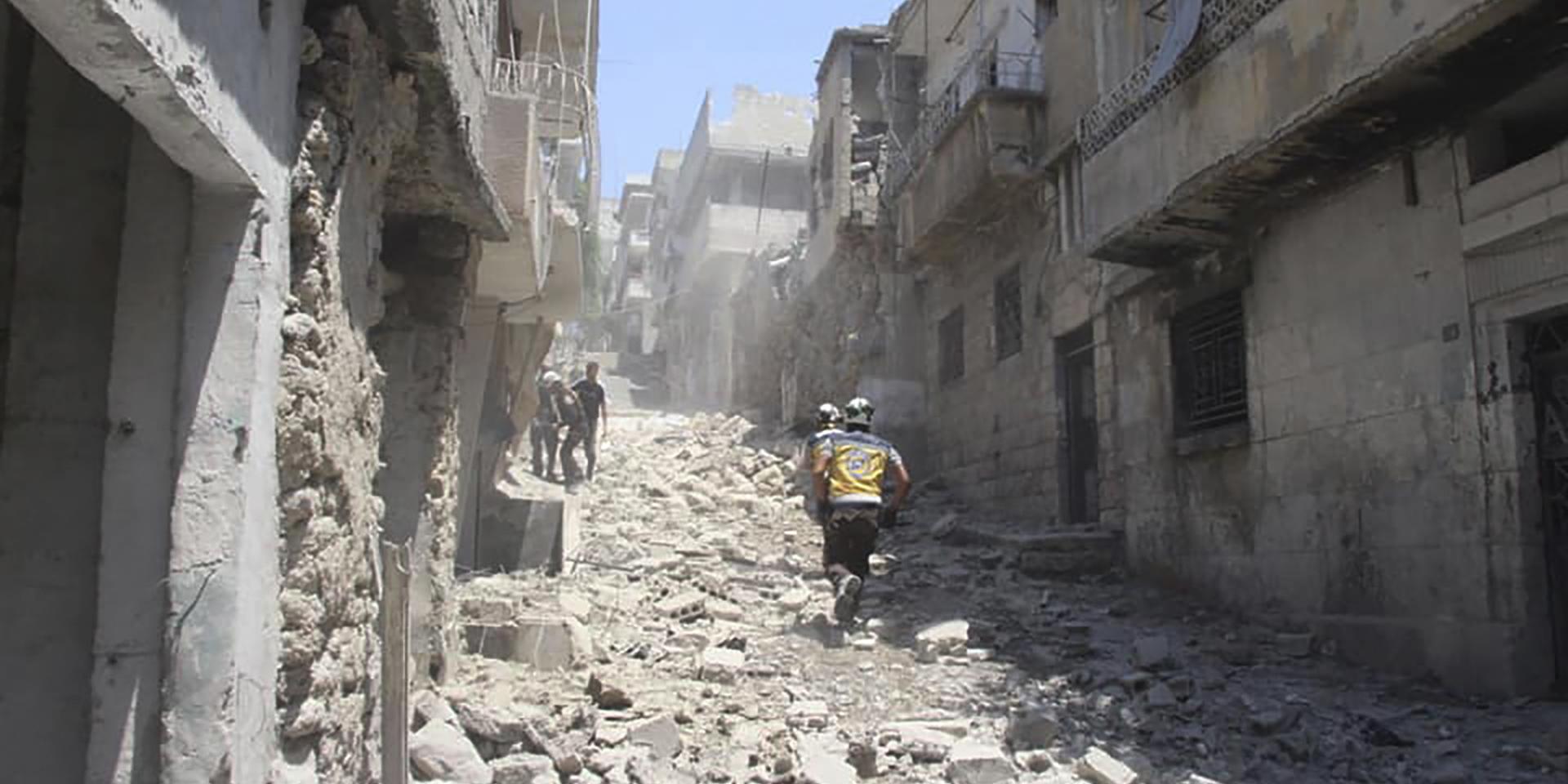 Medlemmar av den syriska organisationen Vita hjälmarna i Idlib springer genom en gata i staden Jisr al-Shugur som utsatts för en av regimens flygattacker. Arkivbild. 