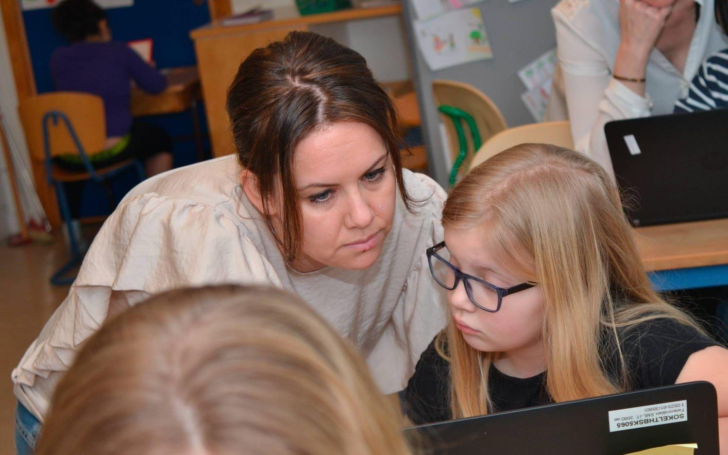 Zandra Rohdin jobbar vid en dator och får hjälp av läraren Caroline Ström.