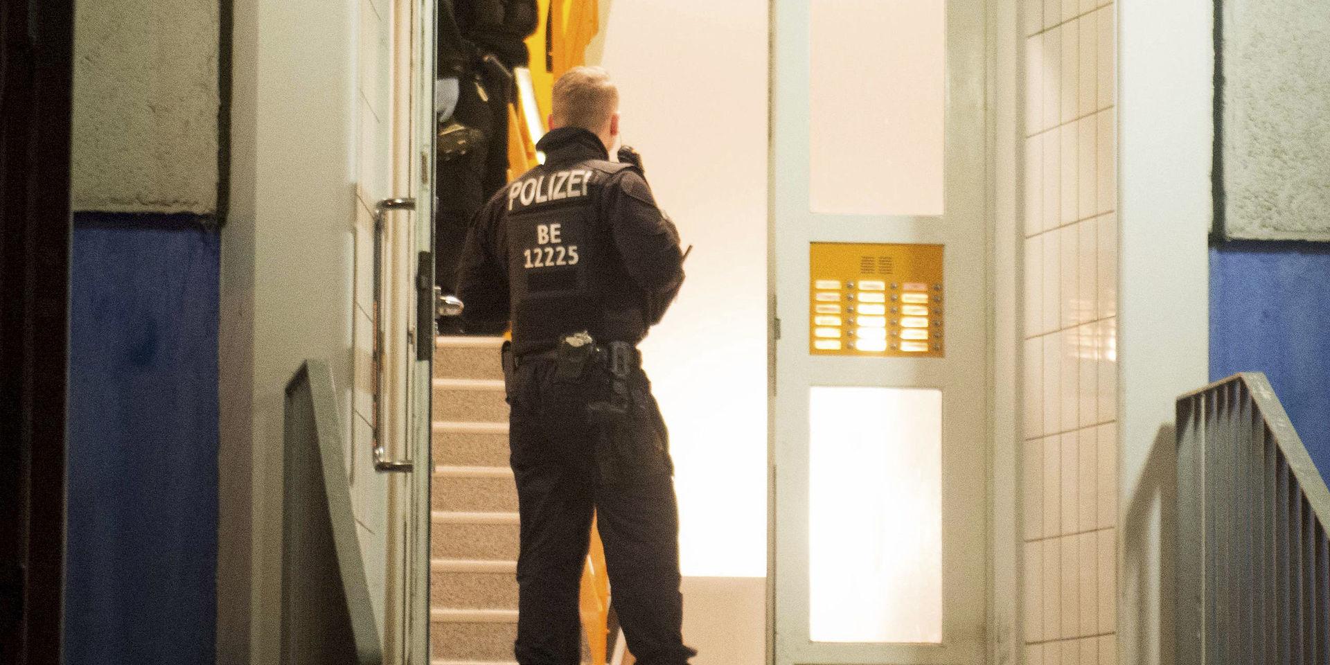 Polis i en trappuppgång i Berlin-området vid en av tisdagens razzior.