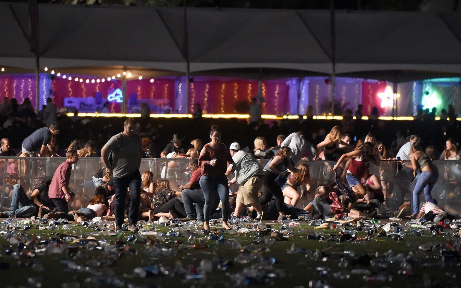 Festivalbesökare springer och tar skydd efter att en person började beskjuta folkmassan med automateld. FOTO: David Becker/Getty Images/AFP
