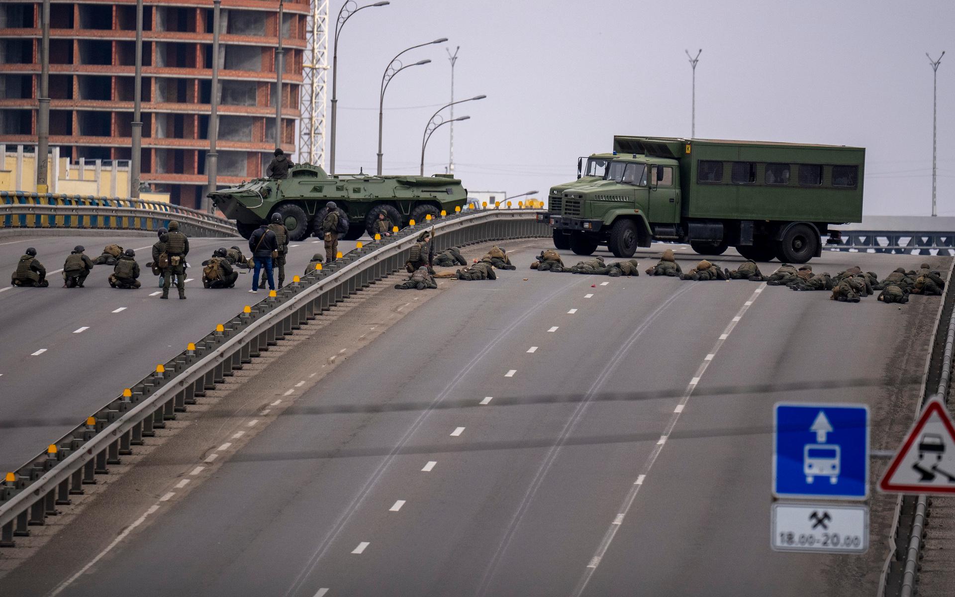 Ukrainska soldater håller sin position på en bro i Kiev. Under fredsförmiddagen har det kommit rapporter om strider i huvudstadens norra delar. 