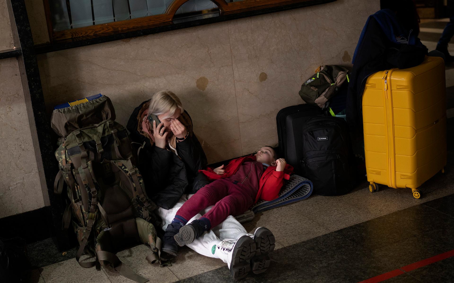 En kvinna med sin dotter väntar på ett tåg för att lämna Kiev efter att Ryssland anfallit staden med missilattacker under natten till torsdag.