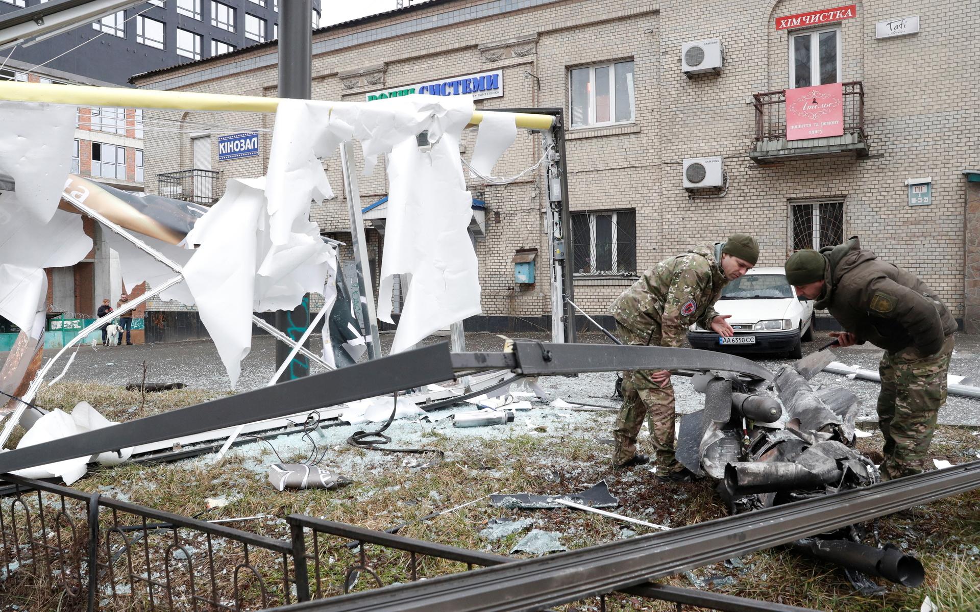 Poliser inspekterar resterna av en missil som föll i Kiev under torsdagsmorgonen.