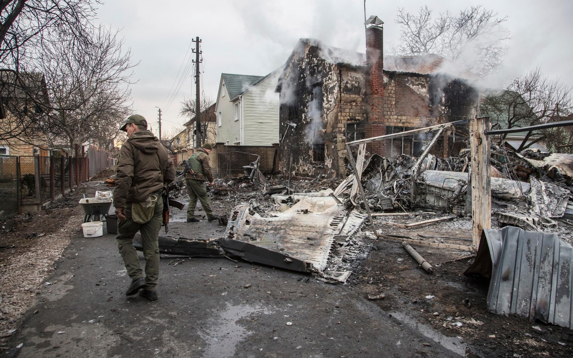 Ukrainska soldater vid ett nedskjutet flygplan i Kiev. Flygplanet kraschade in i två bostadshus som började att brinna. 