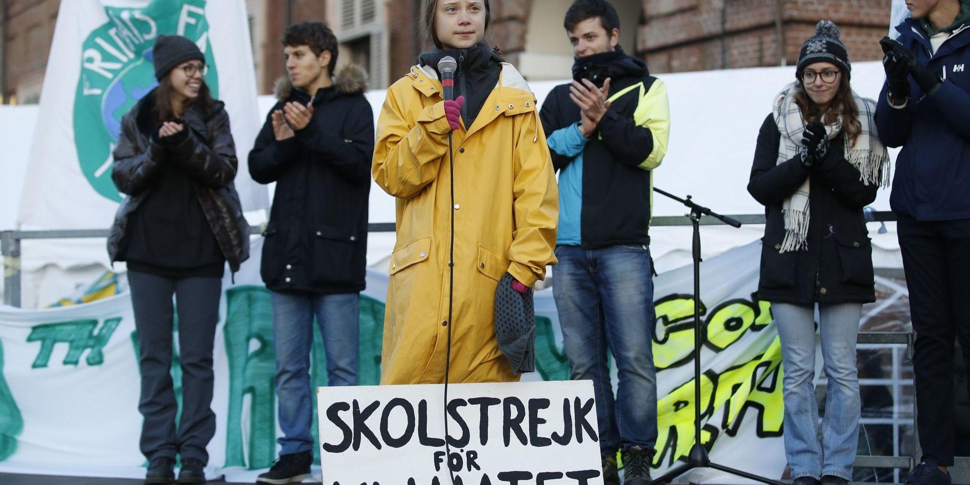 Swedish environmental activist Greta Thunberg attends a climate march, in Turin, Italy, Friday. Dec. 13, 2019. Thunberg was named this week Time&apos;s Person of the Year, despite becoming the figurehead of a global youth movement pressing governments for faster action on climate change. Writing on sign at her feet reads in Swedish &quot;School strike for the climate.&quot; (AP Photo/Antonio Calanni)  XBL101