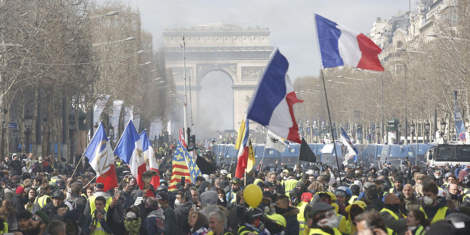 Yellow vests demonstrators invade the Champs Elysees avenue Saturday, March 16, 2019 in Paris. French yellow vest protesters clashed Saturday with riot police near the Arc de Triomphe as they kicked off their 18th straight weekend of demonstrations against President Emmanuel Macron. (AP Photo/Christophe Ena)