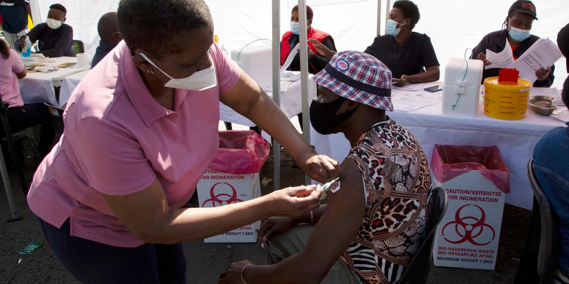 En sköterska delar ut en dos covidvaccin i Soweto i Sydafrika. Bild från augusti.