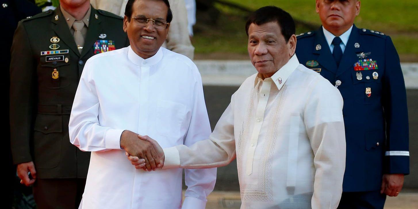 Sri Lankas president Maithripala Sirisena (till vänster) skakar hand med Filippinernas dito Rodrigo Duterte i Manila.
