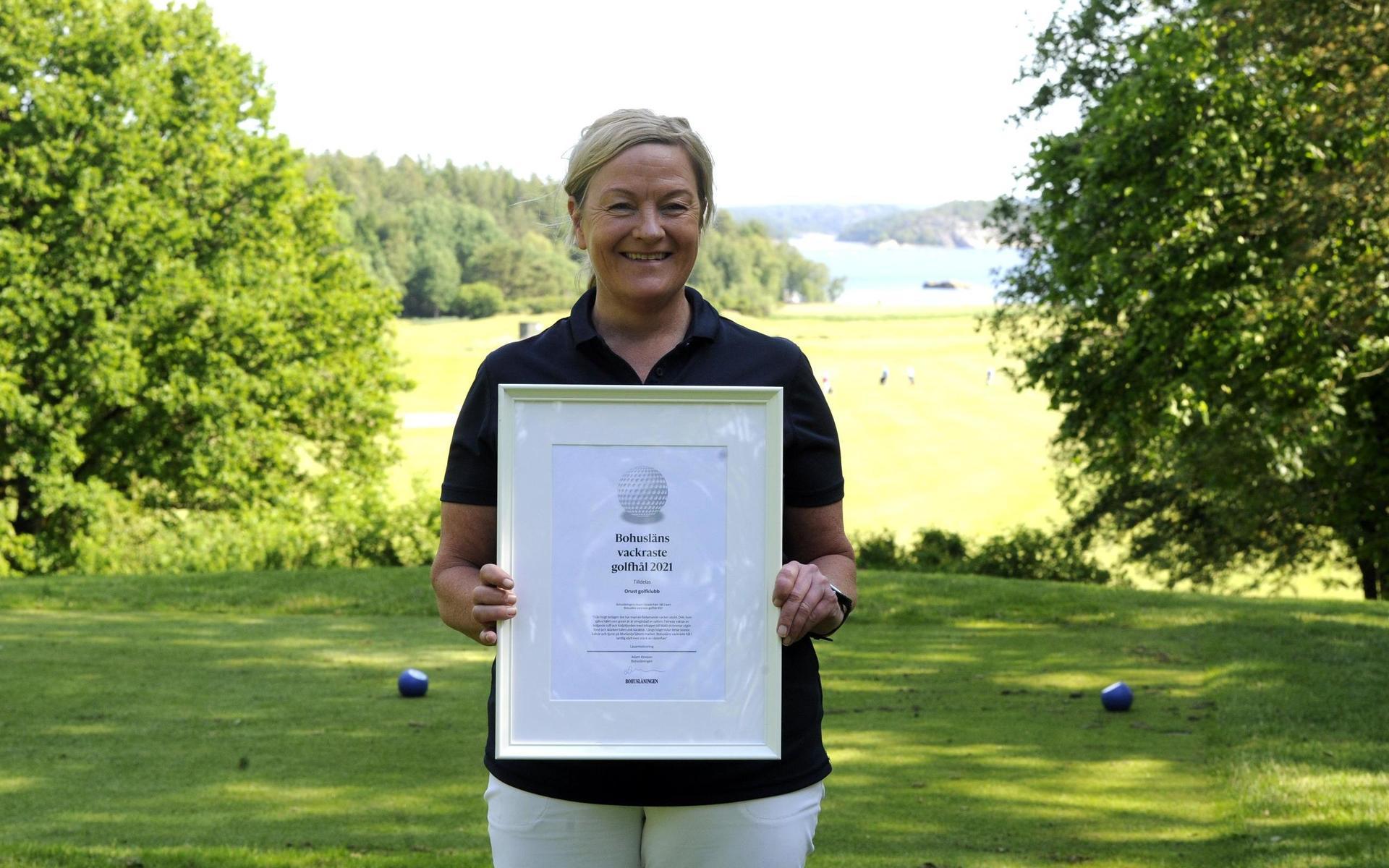 Annika Andersson, kanslichef Orust GK, tar emot diplomet som förkunnar att banan har Bohusläns vackraste golfhål.