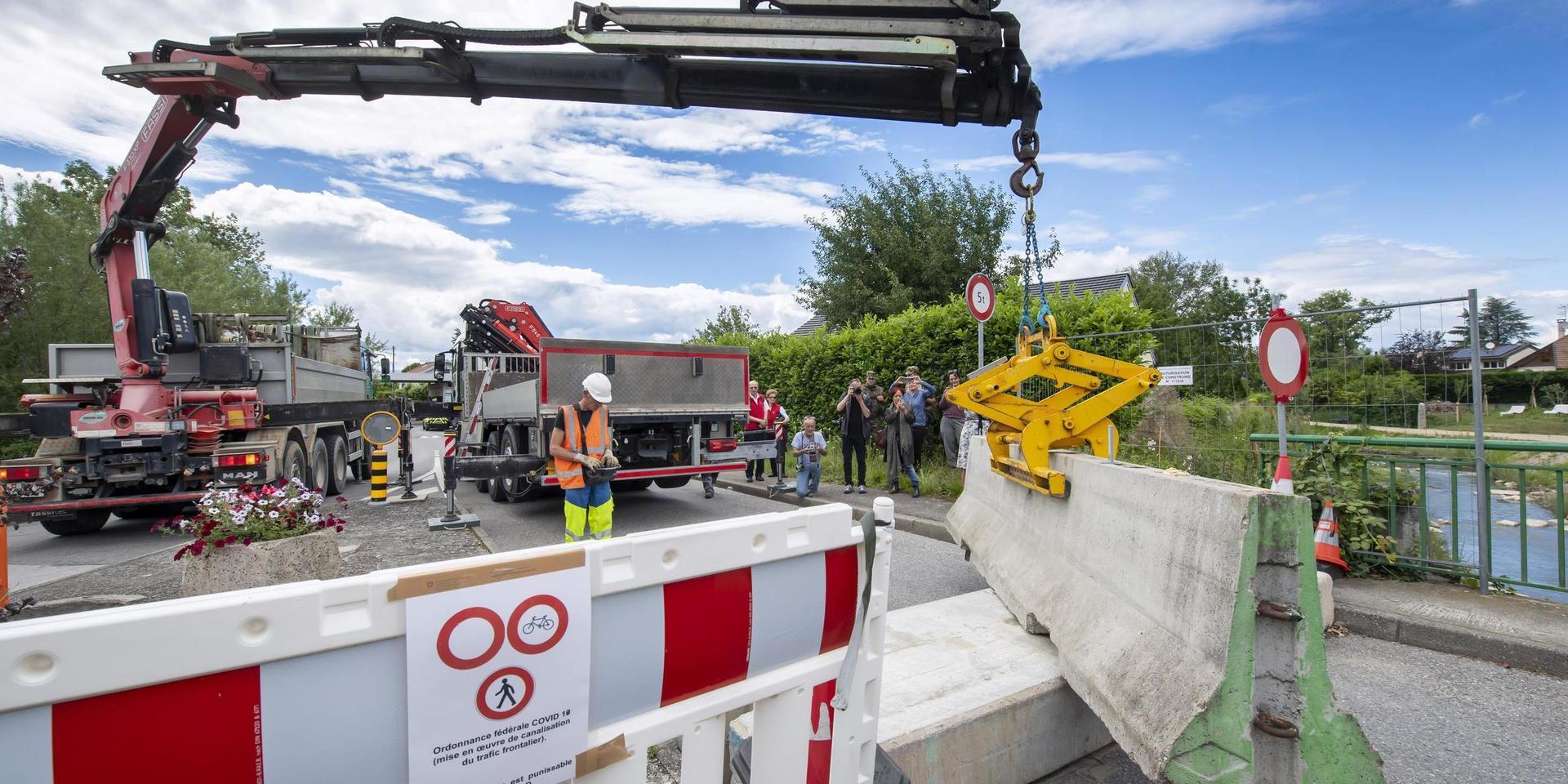 A company employee removes the concrete blocks that closed customs access, in Thonex near Geneva, Switzerland, on Sunday, June 14, 2020. Concrete blocks closed the road at the Swiss-French border during the state of emergency due to the coronavirus COVID-19. Switzerland will open its borders to the EU and EFTA countries and to the United Kingdom on Monday. June 15. Border controls within the Schengen area are abolished and shopping tourism is allowed again. (Martial Trezzini/Keystone via AP)  DMME140