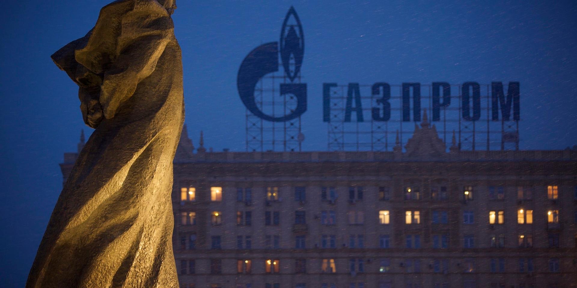 FILE - In this Tuesday, March 4, 2014 file photo, a monument to Ukrainian poet and writer Taras Shevchenko is silhouetted against an apartment building with a sign advertising Russia's natural gas giant Gazprom, in Moscow, Russia. 