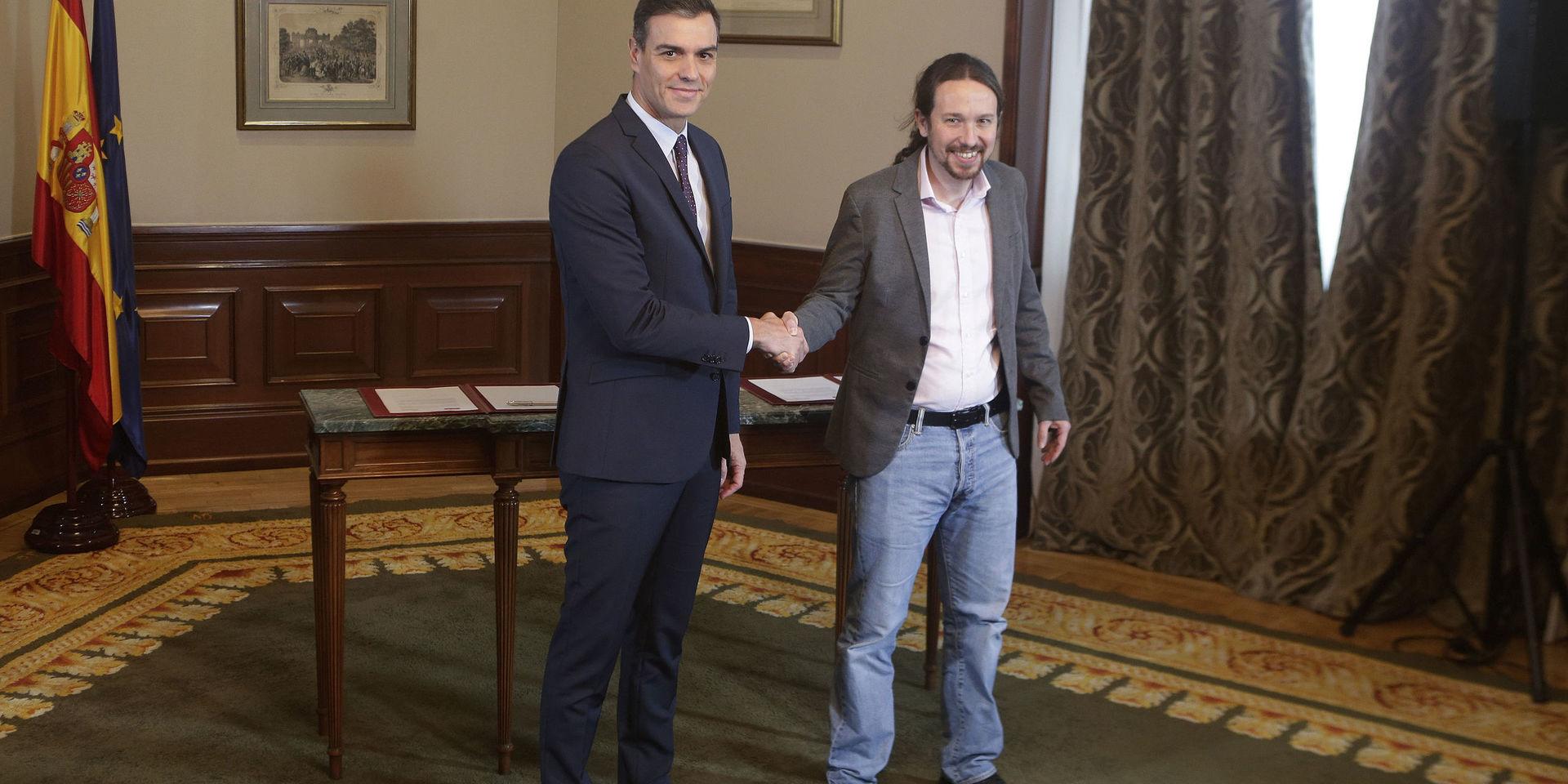 Spaniens tillförordnade premiärminister Pedro Sánchez (tv) med Unidas Podemos-ledaren Pablo Iglesias efter att ha skrivit under en pakt om att bilda en koalitionsregering.