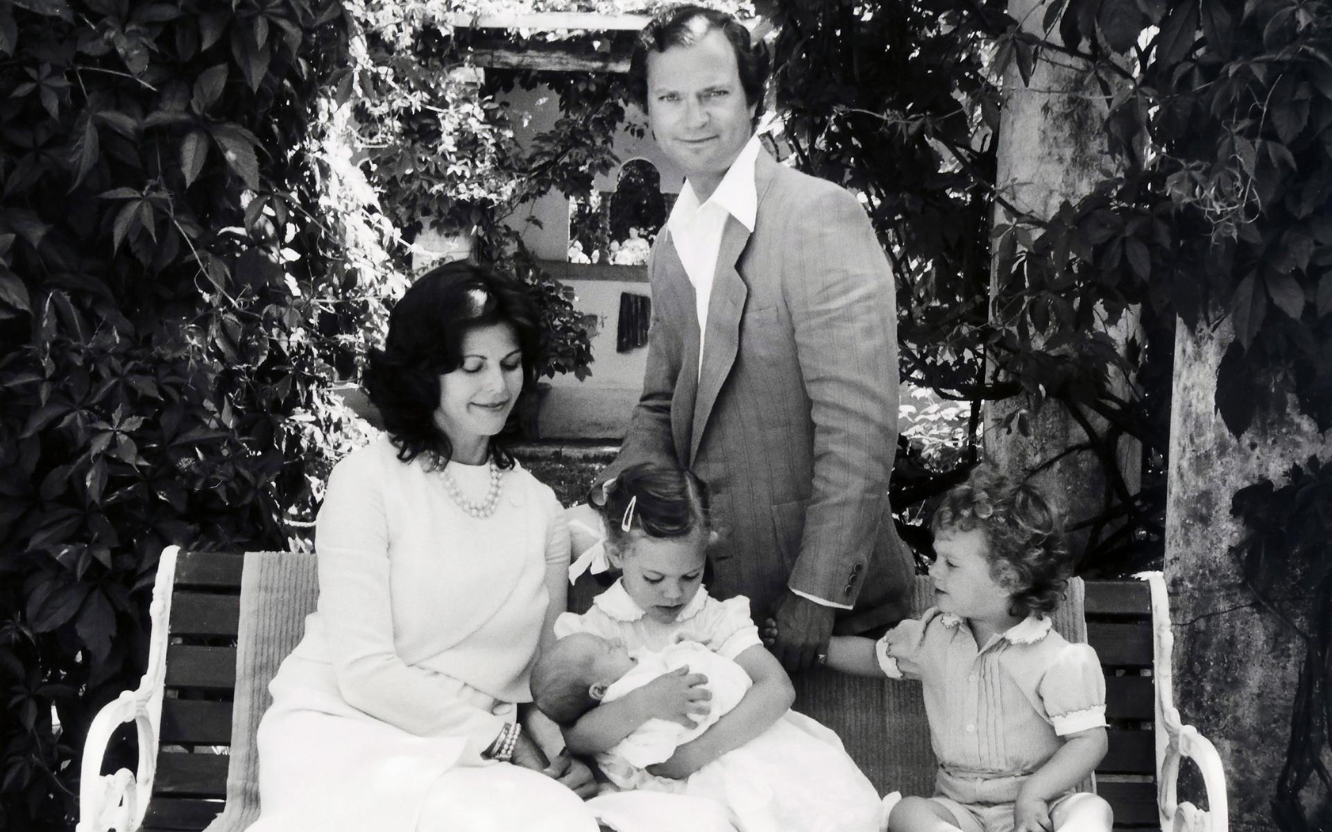 1982 hade kungafamiljen utökats igen, nu med prinsessan Madeleine. Här ligger hon i storasysters famn.  Med på bilden är drottning Silvia, kung Carl XVI Gustaf, kronprinsessan Victoria och prins Carl Philip. Bilden är tagen på Solliden. Arkivbild.
