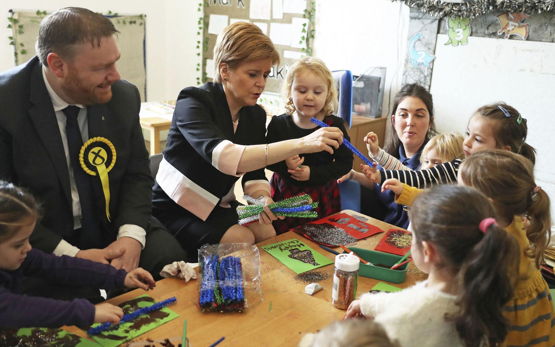 Scottish National Party leader Nicola Sturgeon joins SNP election candidate Owen Thompson, left, during a visit to a nursery in Dalkeith, Scotland, while on the General Election campaign trail, Wednesday Dec. 4, 2019.  Britain&apos;s Brexit is one of the main issues for political parties and for voters, as the UK goes to the polls in a General Election on Dec. 12. (Andrew Milligan/PA via AP)  LRC815
