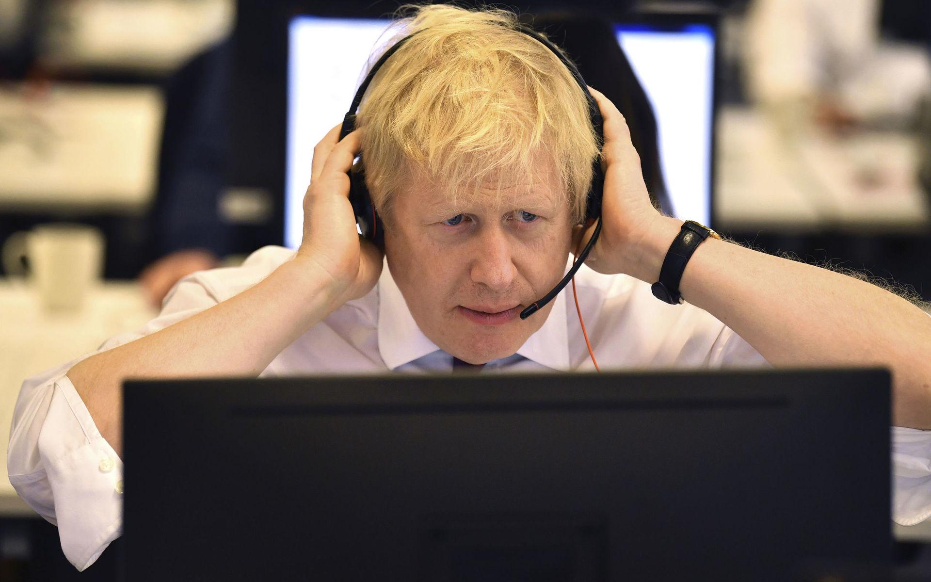 Britain&apos;s Prime Minister Boris Johnson listens to a caller on the phone, at the Conservative Campaign Headquarters Call Centre, while on the General Election trail, in central London, Sunday, Dec. 8, 2019. Britain goes to the polls on Dec. 12.  (Ben Stansall/Pool Photo via AP)  AMB110