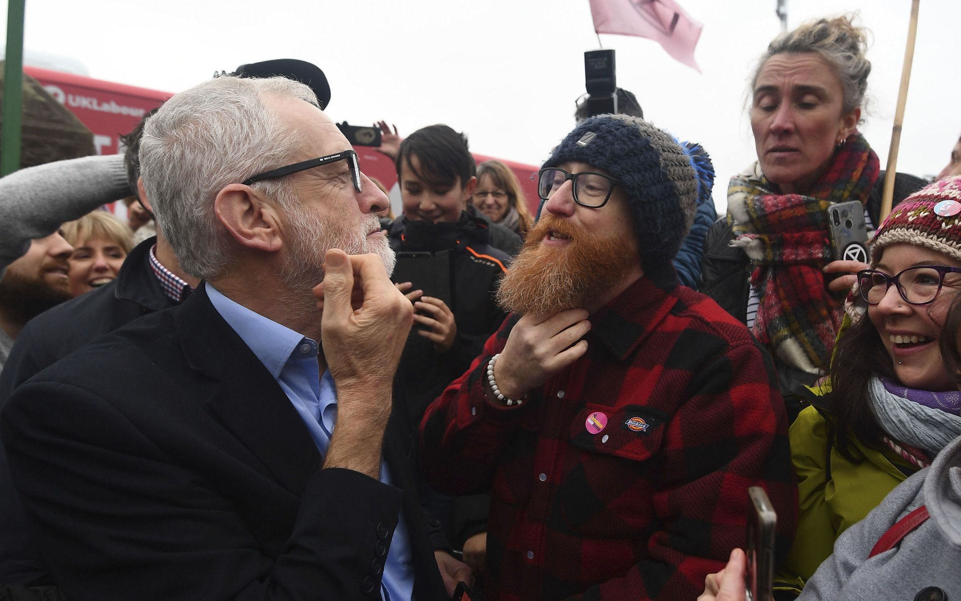 Labour Party leader Jeremy Corbyn compares beards with a supporter during a visit to Swansea, while on the General Election campaign trail in Wales, Saturday, Dec. 7, 2019. Britain goes to the polls on Thursday, Dec. 12. (Victoria Jones/PA via AP)  LLT806