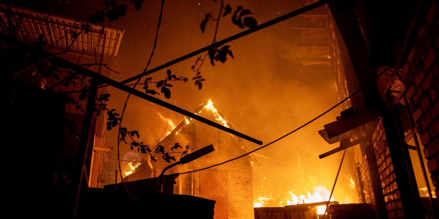 En byggnad i Cherson står i brand efter att ha träffats av rysk eld i lördags.