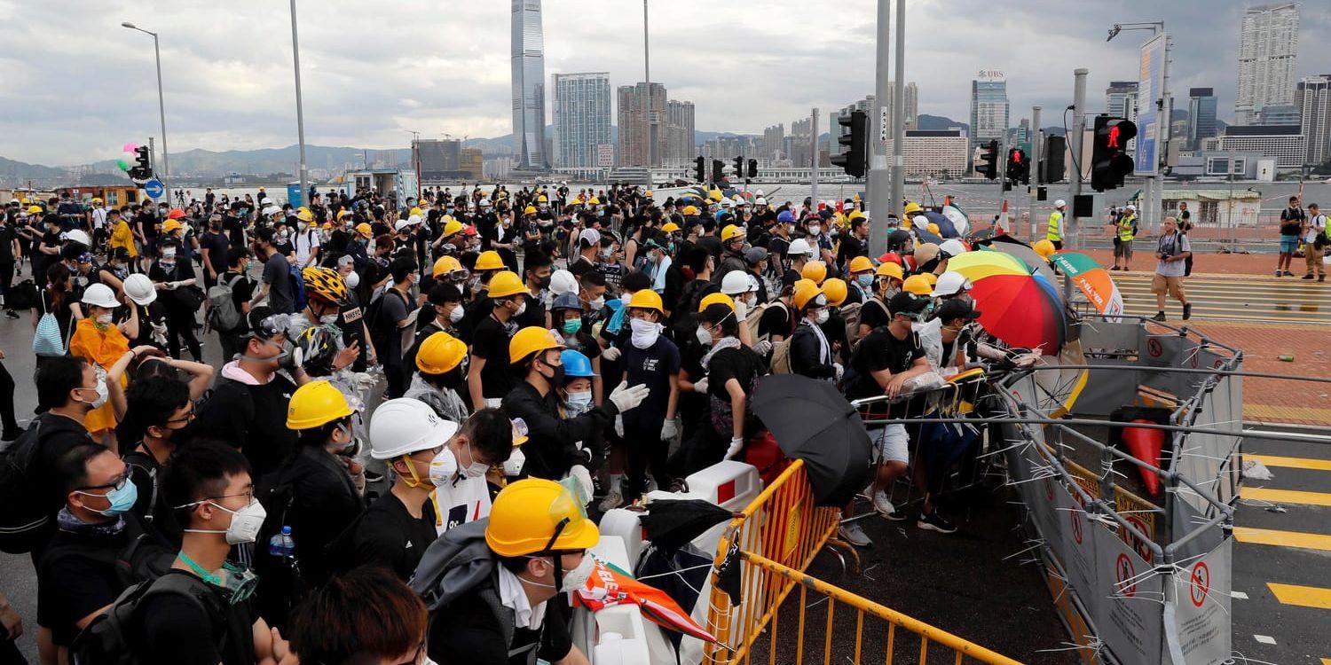 Demonstranter blockerar en väg i Hongkong.