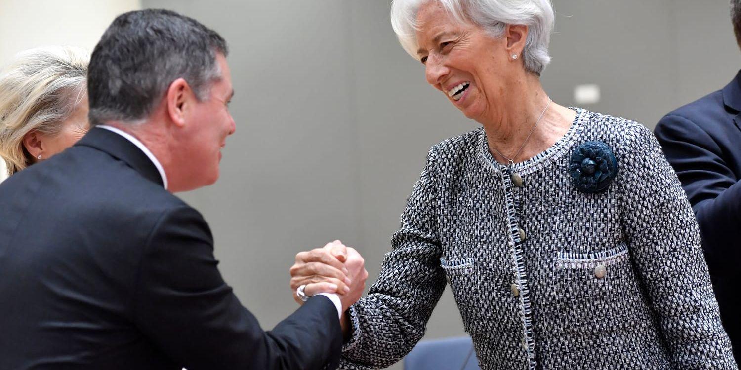 Eurogruppens ordförande Paschal Donohoe och Europeiska centralbankens chef Christine Lagarde skakar hand inne på EU-toppmötet i Bryssel.