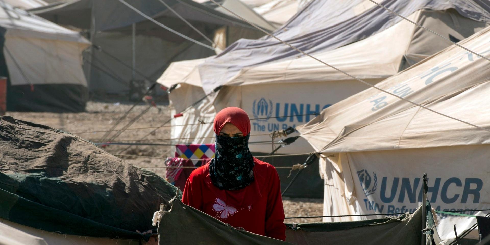 A woman looks out from her tent at an internally displaced persons camp in Irbil, Iraq on Thursday, Sept. 4, 2014. The UNHCR-sponsored camp was originally built for Syrian refugees, but re-opened for those fleeing Mosul. Over 600 families live here. In June 2014, the Islamic State group spearheaded an offensive, seizing vast swaths of northern Iraq, including the country's second largest city, Mosul. (AP Photo/The Canadian Press, Ryan Remiorz) / TT / kod 436