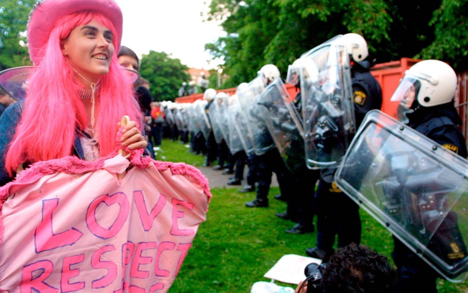 Rosa protest framför poliserna som håller demonstranter borta från containrar som innesluter Hvitfeldtska. Bild: Måns Langhjelm
