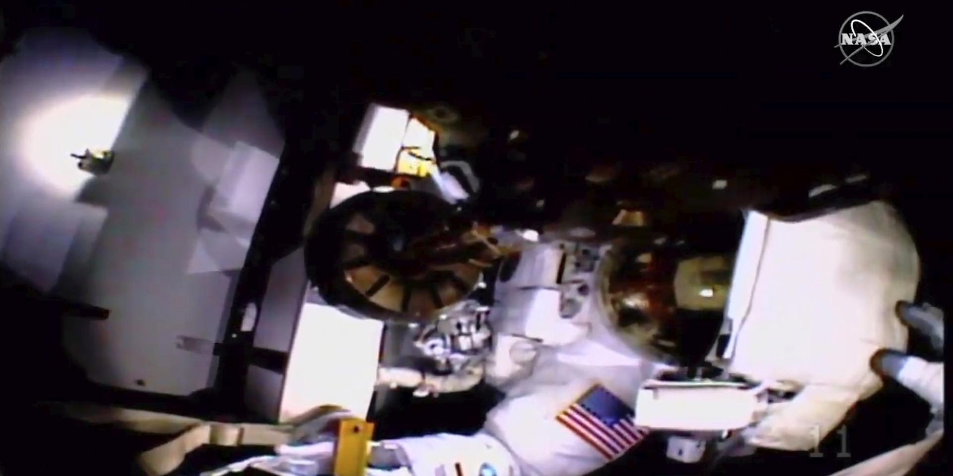 Här hjälps astronauterna år sedan videokameran och ljuset på Christina Kochs hjälm lossnat. Jessica Meirs handske syns till höger vid hjälmen.