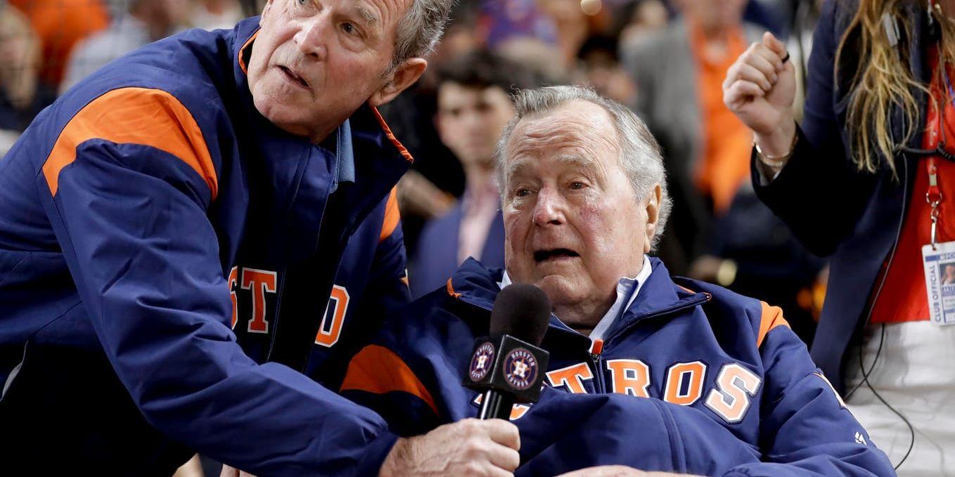 De tidigare amerikanska presidenterna far och son George Bush (t h) och George  W Bush under en baseballmatch förra månaden. Ingen av dem röstade på sin partikamrat Donald Trump i förra årets val.