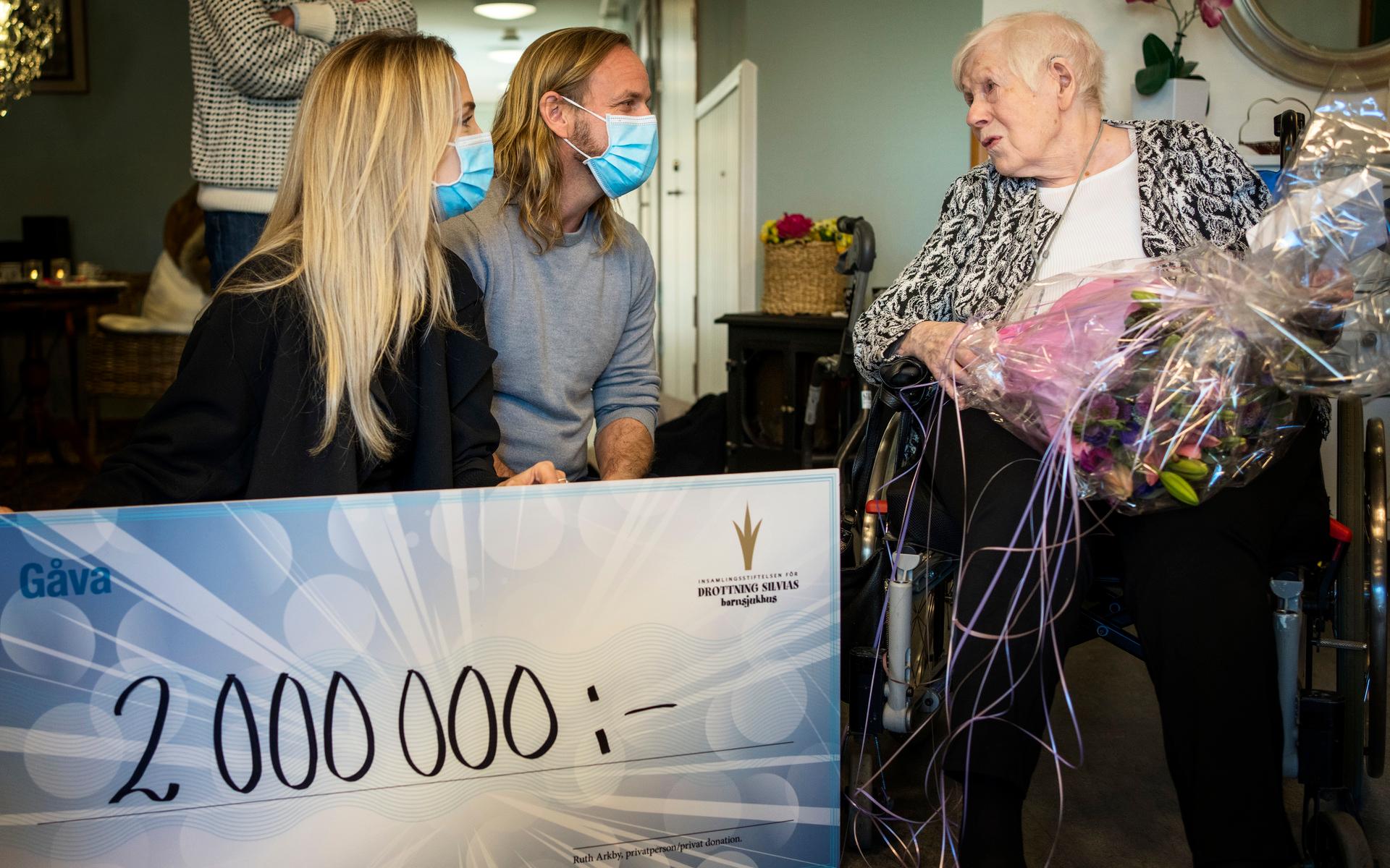Ruth Arkby, 94, lämnar över en jättecheck till Lisa Tisell och Palle Stenberg på Insamlingsstiftelsen för Drottning Silvias barnsjukhus.