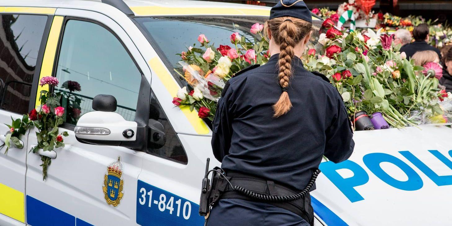 En polisbil överöst med blommor utanför Åhlens på Drottninggatan, tre dagar efter terrordådet i Stockholm city. Arkivbild.