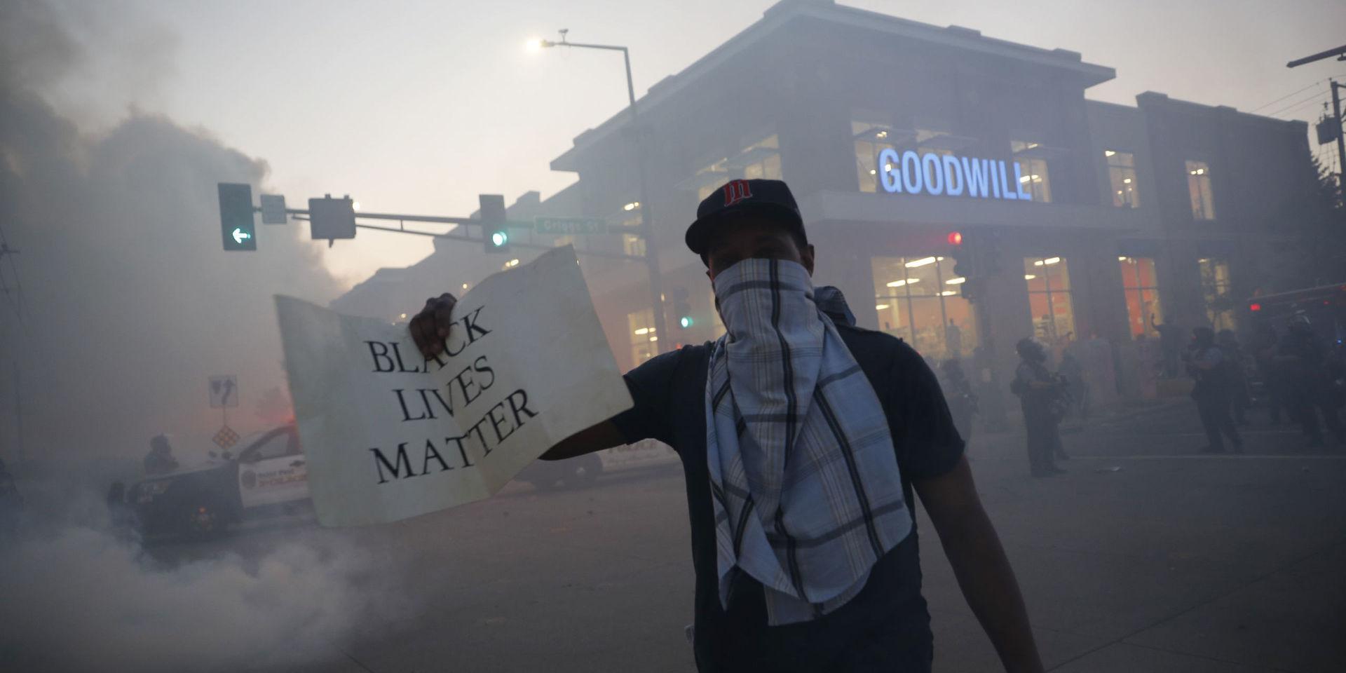 En demonstrant i Minneapolis tvillingstad Saint Paul håller upp en skylt med texten 'Black Lives Matter' vilket kan översättas med 'Svarta liv har betydelse'.