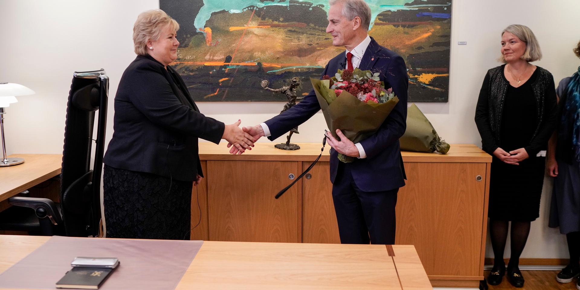 Avgående statsminister Erna Solberg överräcker nyckeln till statsministerns kontor till nytillträdde Jonas Gahr Støre.